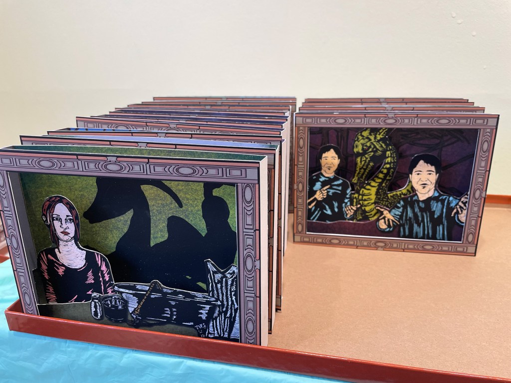 View of a box with many tunnel books stacked.